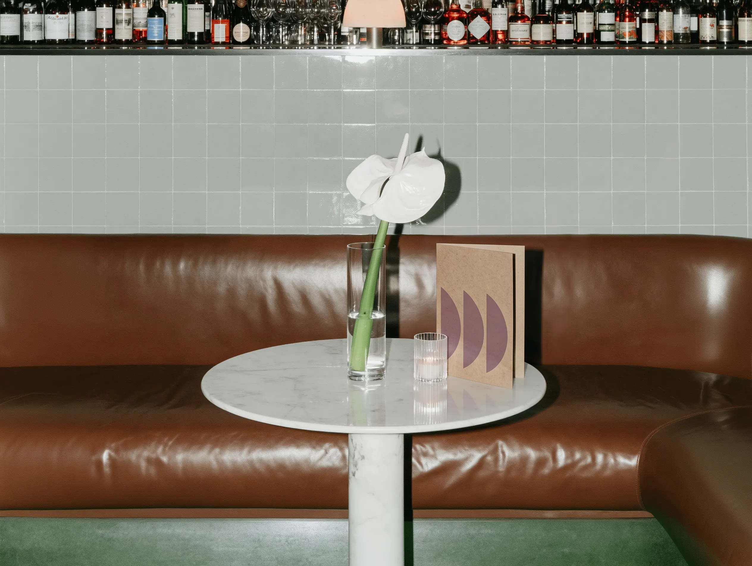 Leather banquette and a marble table with a menu card