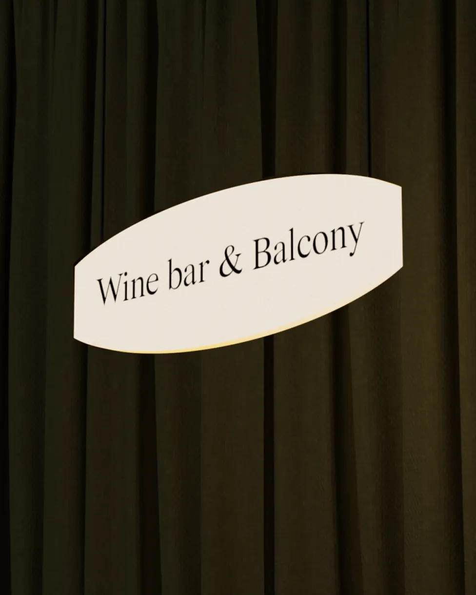 Wine bar & Balcony sign in front of a dark curtain